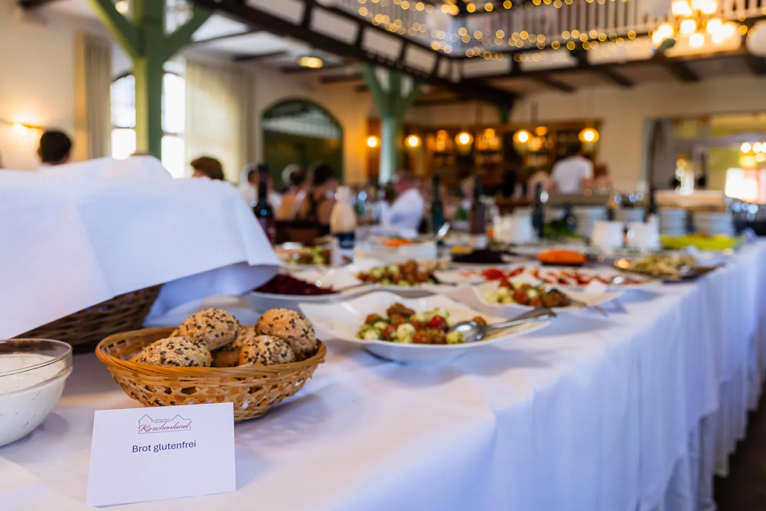 Fährhaus Kirschenland – Ein reichhaltiges Buffet bei einem Abiball in Stade mit Körben voller Brötchen und verschiedenen Salaten auf einer festlich gedeckten Tafel. | Jannes Romund Fotografie