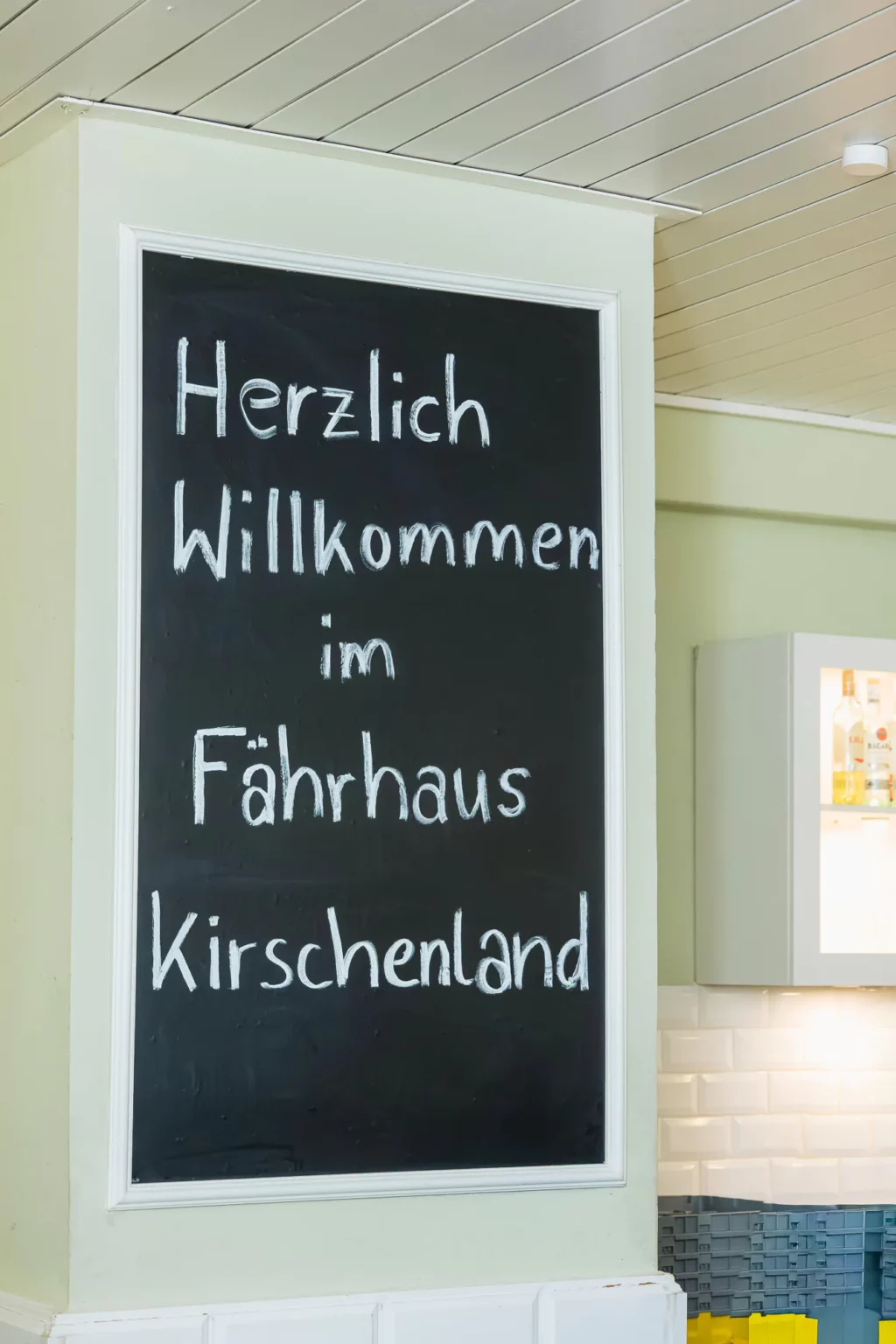 Fährhaus Kirschenland – Eine handgeschriebene Kreidetafel mit der Aufschrift Herzlich Willkommen im Fährhaus Kirschenland als Begrüßung für Gäste bei einem Abiball. | Jannes Romund Fotografie