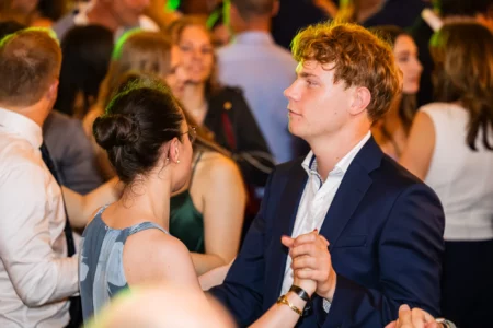 Fährhaus Kirschenland – Ein junges Paar tanzt eng umschlungen auf einem Abiball in Stade, umgeben von weiteren feiernden Abiturienten in festlicher Abendgarderobe. | Jannes Romund Fotografie
