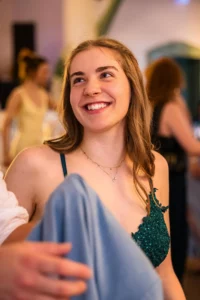 Fährhaus Kirschenland – Eine glückliche Abiturientin in einem eleganten, dunkelgrünen Abendkleid mit Spitze lächelt strahlend während der Abiball Feier in Stade. | Jannes Romund Fotografie