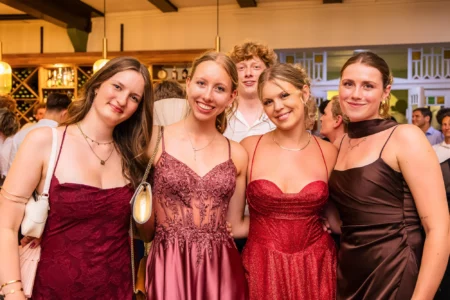 Fährhaus Kirschenland – Vier junge Frauen in eleganten Abendkleidern und ein junger Mann lächeln gemeinsam bei einem Abiball in Stade in die Kamera. | Jannes Romund Fotografie
