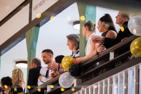Fährhaus Kirschenland – Gäste beobachten von einer Empore mit Luftballons den Abiball in Stade und Hamburg, festgehalten durch Jannes Romund Abiballfotografie. | Jannes Romund Fotografie