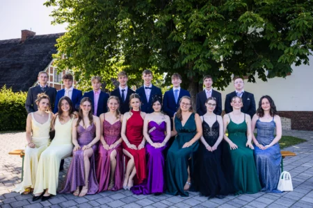 Abiballfotograf Stade – Gruppe von Jugendlichen in eleganten Abendkleidern und Anzügen, posierend unter einem Baum. | Jannes Romund Fotografie