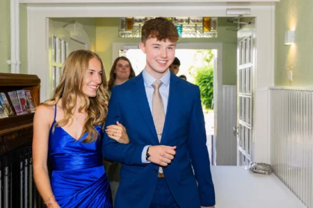 Fährhaus Kirschenland – Ein strahlendes Abiturientenpaar in festlicher Kleidung betritt Arm in Arm den Veranstaltungsort für ihren Abiball in der Region Hamburg. | Jannes Romund Fotografie